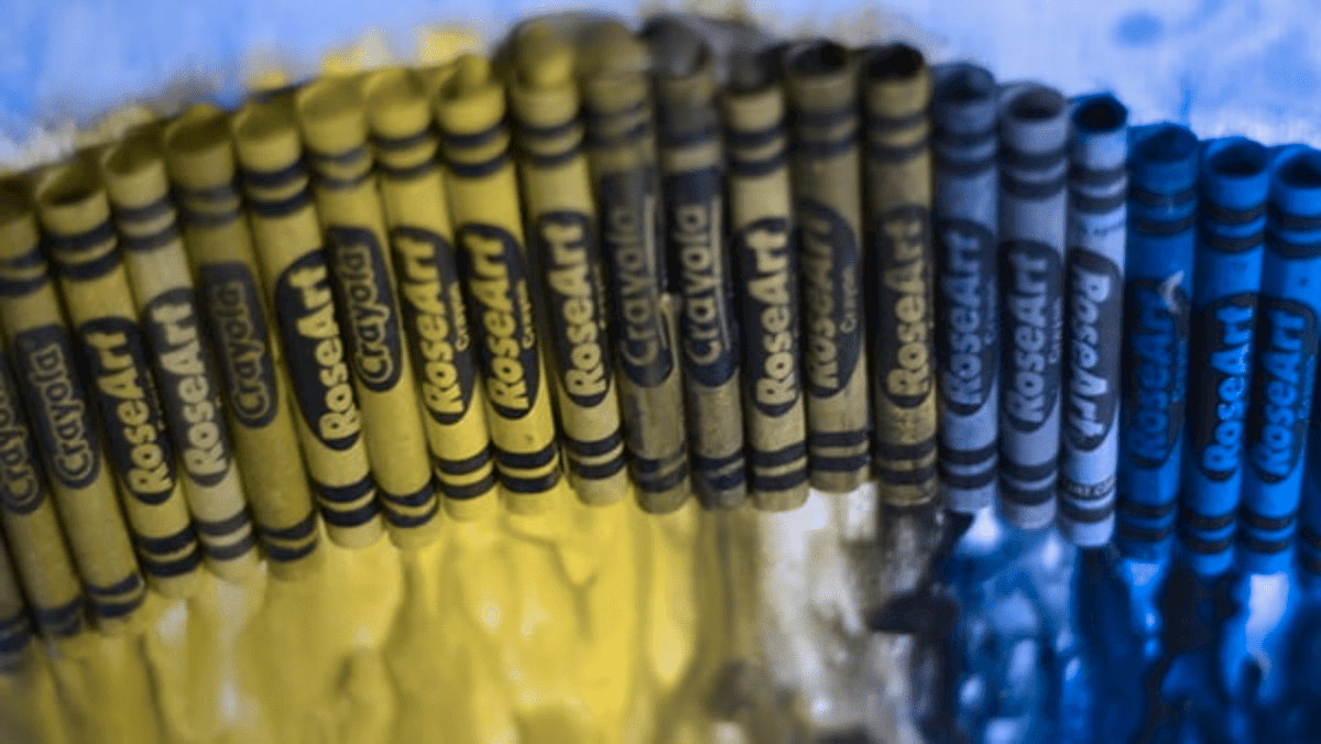 El impacto de simular deuteranopia en una imagen colorida de crayones derretidos.